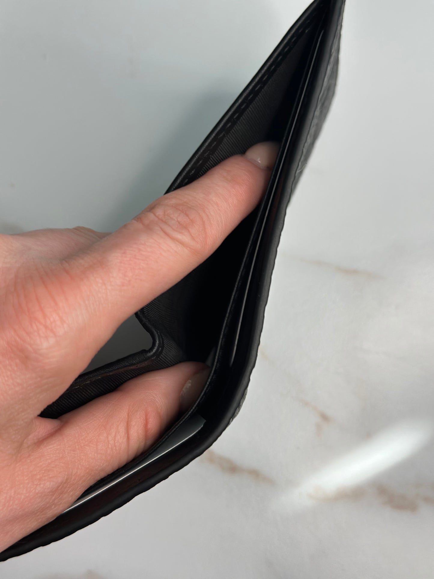 Pre-owner Gucci GG embossed black bifold wallet
