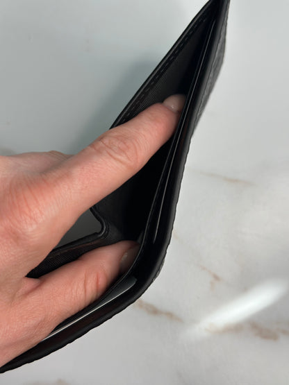 Pre-owner Gucci GG embossed black bifold wallet