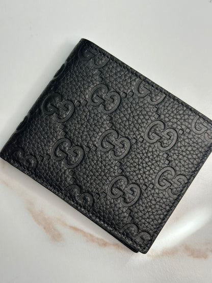 Pre-owner Gucci GG embossed black bifold wallet